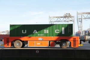 orange and green cargo truck move a shipping container